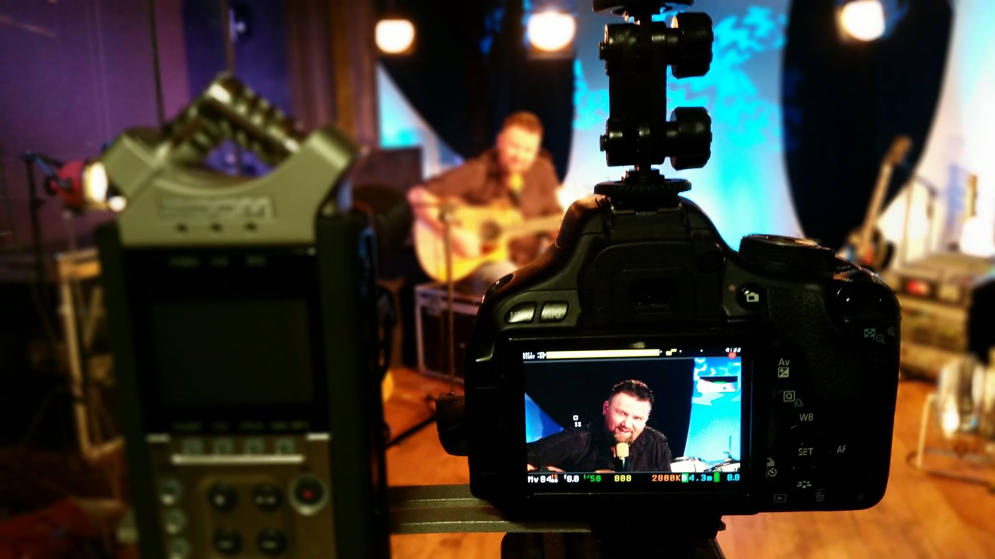 Studio camera framing a seated musical performance